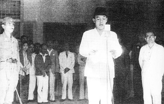 Beeld: Op de voorgalerij van zijn huis in Jakarta leest Soekarno met Hatta aan zijn zijde op 17 augustus 1945 de proclamatie voor. Fotograaf: Frans Mendoer.